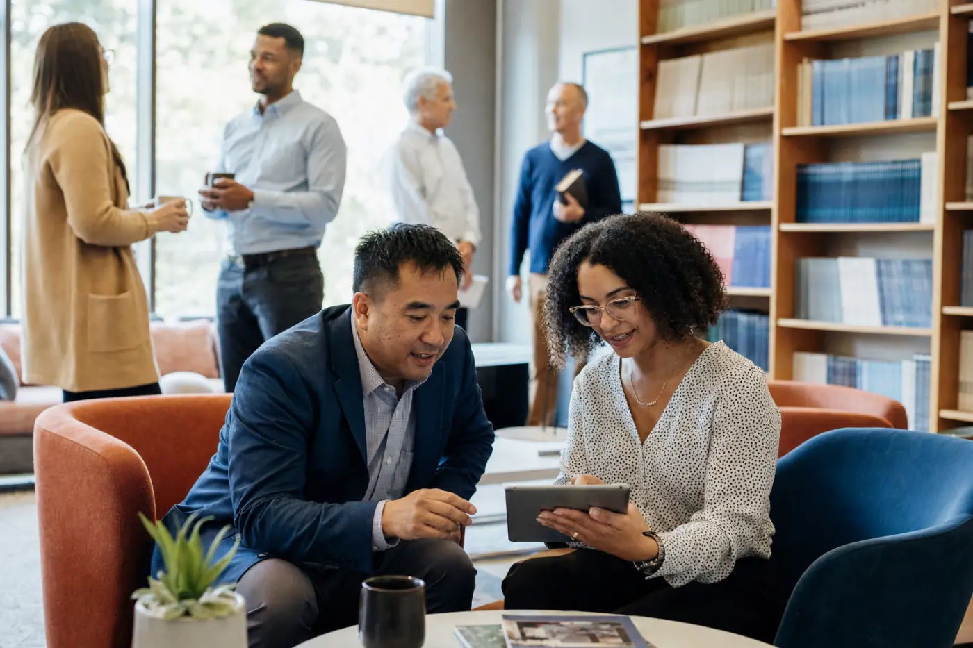 Association members reviewing a journal article on a tablet in a headquarters lounge